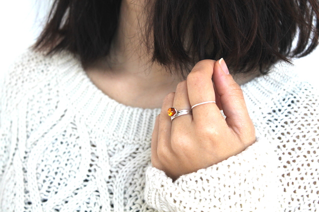 Bague en ambre et argent avec un pull en                           laine blanc