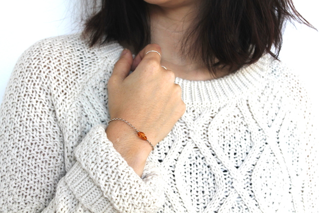 Petit bracelet en ambre et argent avec un gros pull en laine